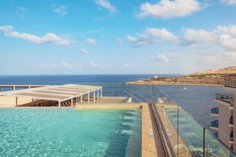 Piscina infinita con vistas al mar Mediterráneo en el QAWRA Palace Resort & SPA en Malta