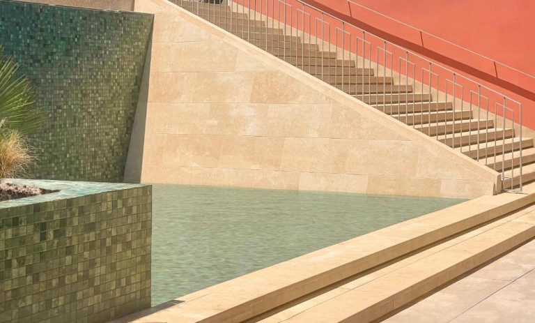 Piscina exterior con escaleras de piedra y mosaicos verdes en Qawra Palace Resort & SPA