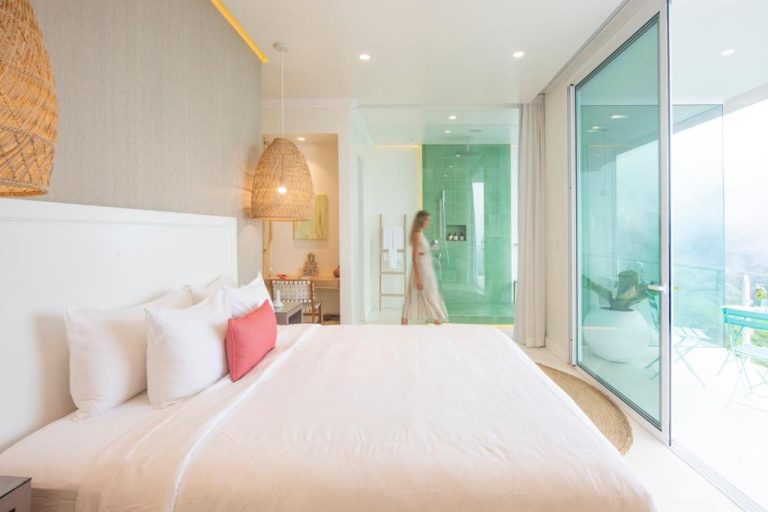 Habitación suite de lujo con baño abierto de azulejos verdes y terraza en The Retreat Costa Rica Wellness Resort