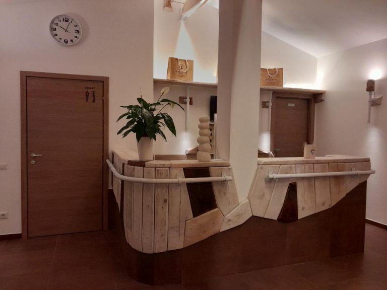 Recepción rústica de madera con planta decorativa y reloj de pared en Resort La Ficaccia