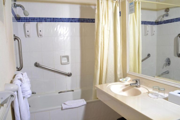 Baño accesible con bañera adaptada y barras de apoyo en el Blue Orchids Beach Hotel