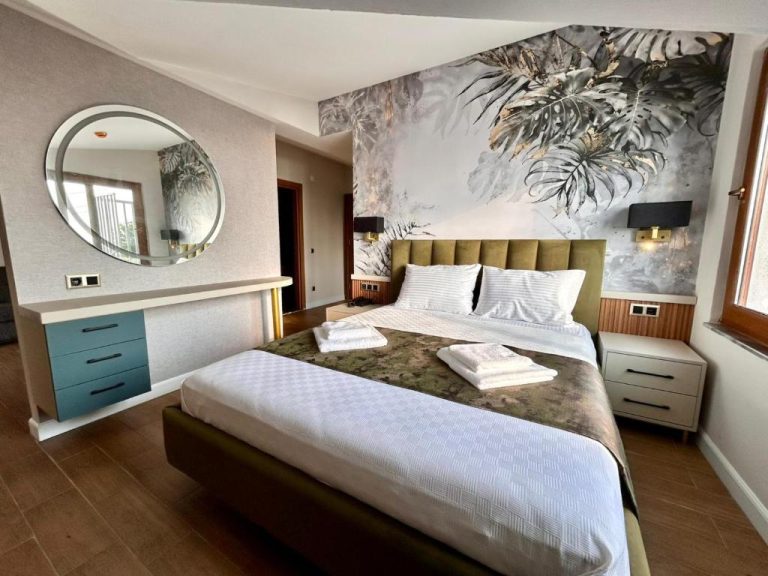 Habitación doble deluxe con cama matrimonial y mural tropical en Castello by Mediterra Hotel