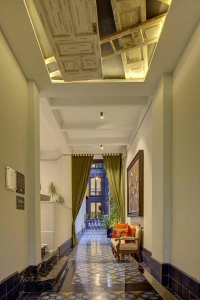 Pasillo elegante con suelo hidráulico y techo decorativo de madera en Roso Guest House