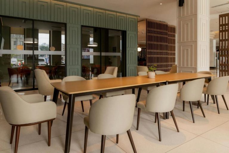 Amplio salón comedor con mesa de reuniones y sillas beige en el Sheraton Lima Historic Center