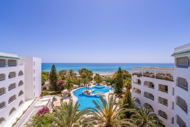Piscina exterior rodeada de palmeras con vistas al mar Mediterráneo en el Hotel Sol Azur