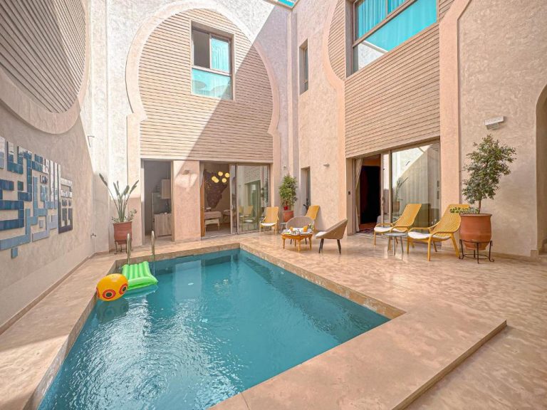Piscina interior en el patio central del Riad Timija con tumbonas y arquitectura árabe tradicional