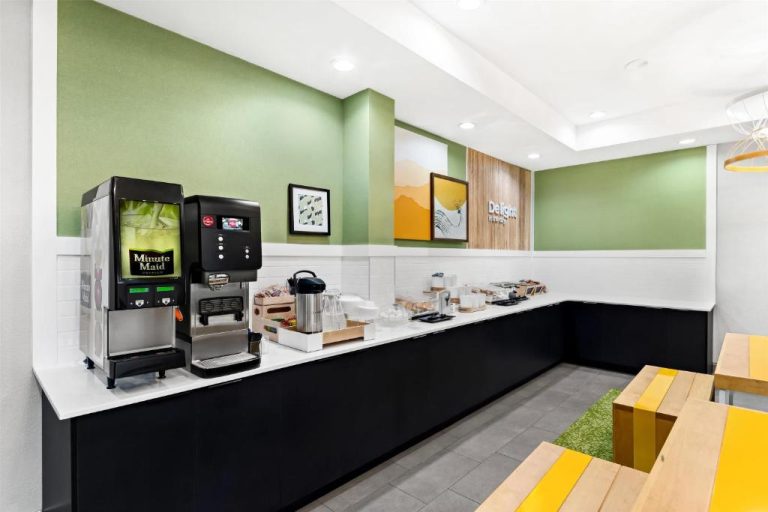 Zona de desayuno buffet con máquina Minute Maid y cafetera en Spark by Hilton Panama City Beach