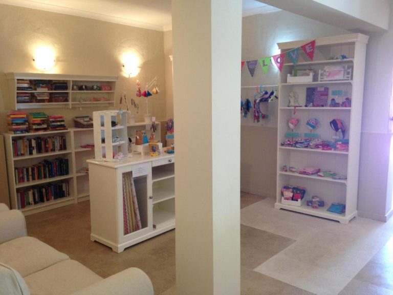 Tienda interior del Hotel Vilamar con estanterías de libros, accesorios infantiles y decoración colorida