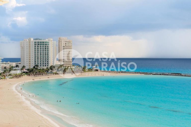 Vista aérea de la playa y el mar turquesa frente al Ocean Vibes Suites by Casa Paraiso en Cancún