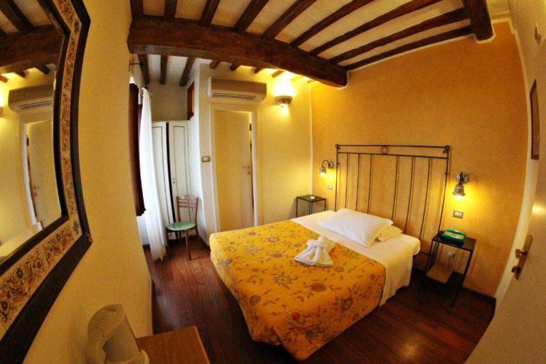 Habitación doble con vigas de madera y cama matrimonial amarilla en Primavera Mini Hotel
