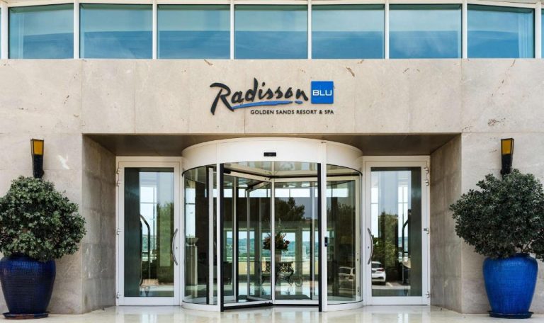 Entrada principal con puerta giratoria del Radisson Blu Golden Sands Resort & Spa en Malta