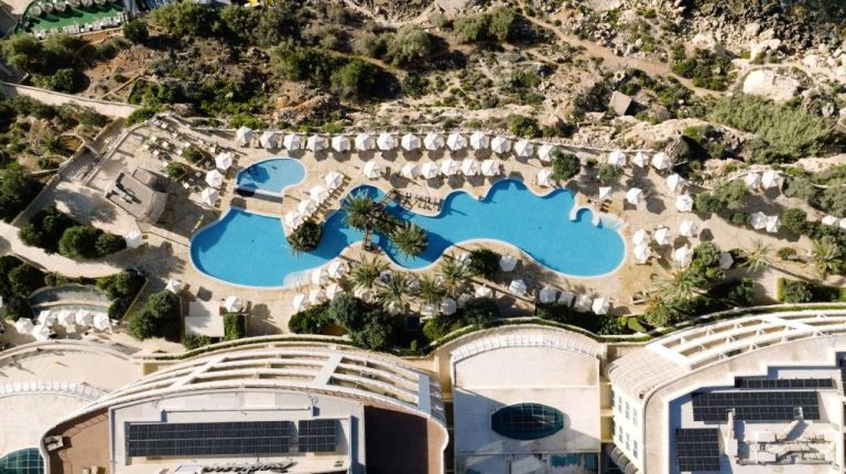 Vista aérea de las piscinas exteriores del Radisson Blu Resort & Spa Malta Golden Sands con tumbonas