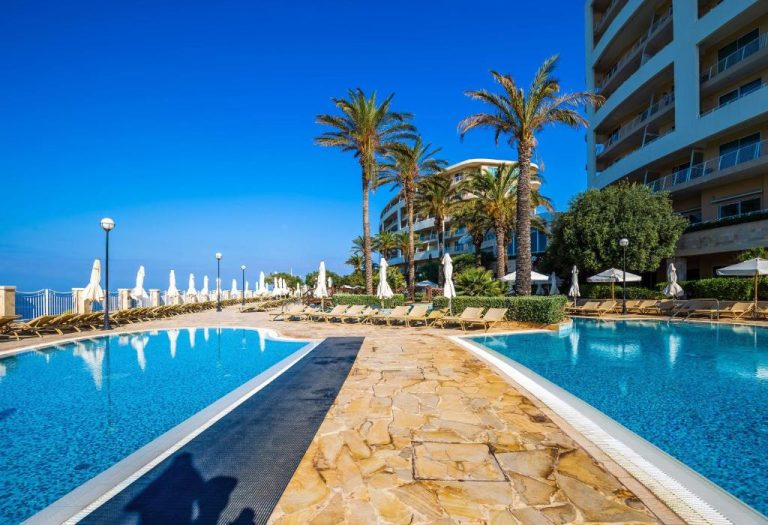 Piscina exterior con tumbonas y palmeras del Radisson Blu Resort & Spa Malta Golden Sands