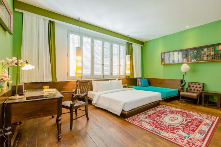 Habitación deluxe con paredes verdes y suelo de madera en The Memory at On On Hotel Phuket