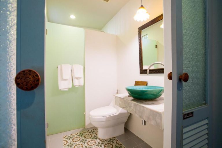 Baño elegante con lavabo turquesa y suelo hidráulico en The Memory at On On Hotel