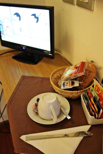 Servicio de desayuno en habitación del Primavera Mini Hotel con taza, snacks y cesta de galletas
