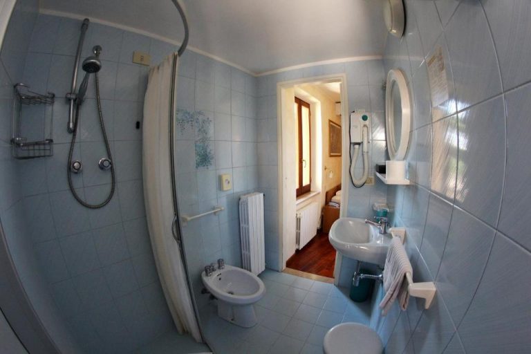 Baño completo con ducha, bidé y lavabo del Primavera Mini Hotel con azulejos azules