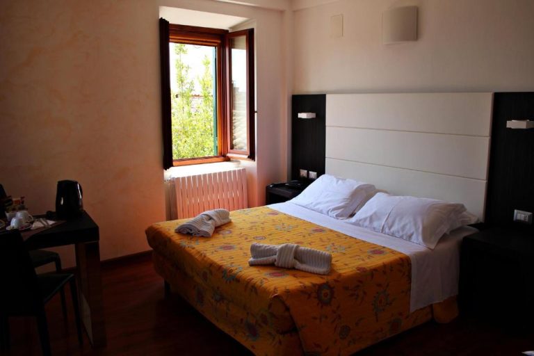 Habitación doble con cama matrimonial y ventana con vistas verdes en Primavera Mini Hotel