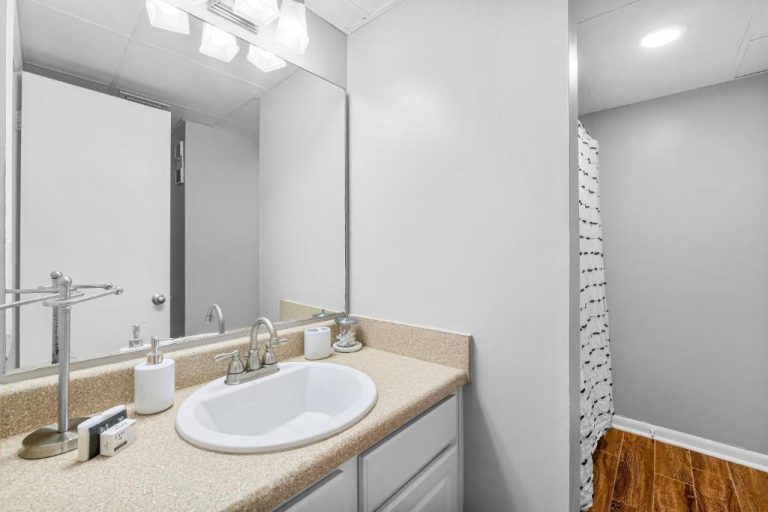 Baño moderno con lavabo y encimera de granito en Sunbird of Panama City Beach 503E