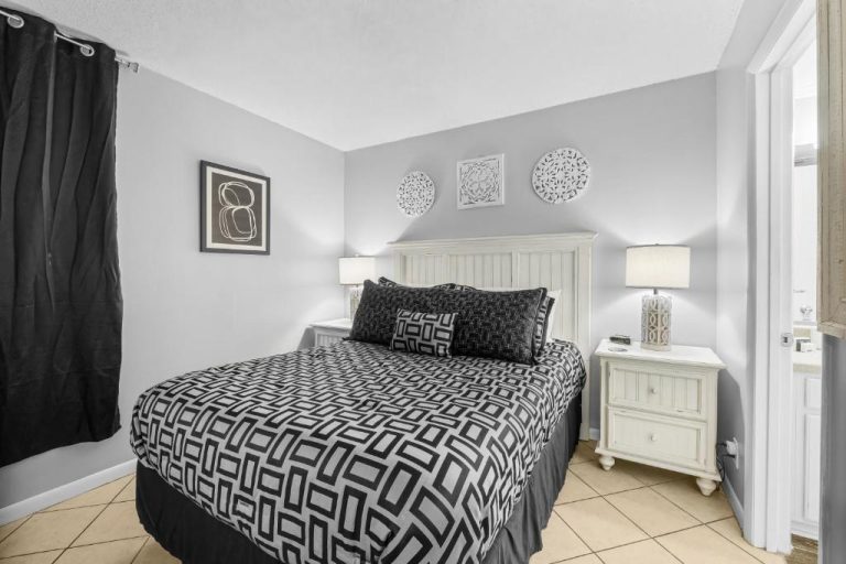 Habitación doble con cama y decoración en blanco y negro en Sunbird of Panama City Beach 503E