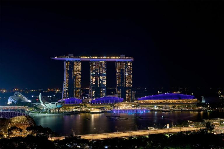 Vista nocturna del Wyndham Singapore Hotel con Marina Bay Sands y jardines iluminados al fondo