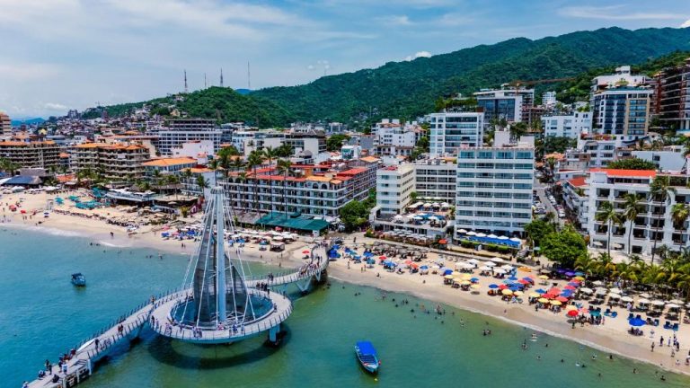 Vista aérea del Delfin Beachfront Resort en Puerto Vallarta con el muelle Los Muertos y playa frente al hotel