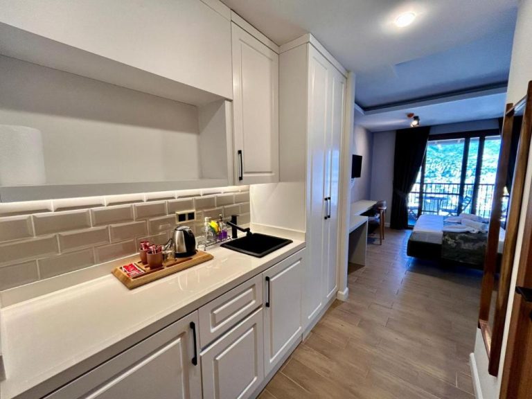 Cocina equipada con encimera blanca y zona de estar en el Castello By Mediterra Hotel