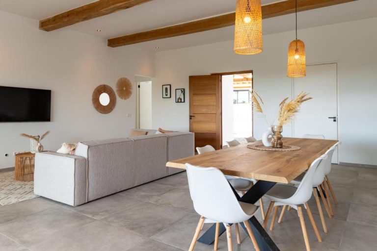Amplio salón comedor con mesa de madera y sillas blancas en Luxury Villa con Piscina Privada para 8 personas