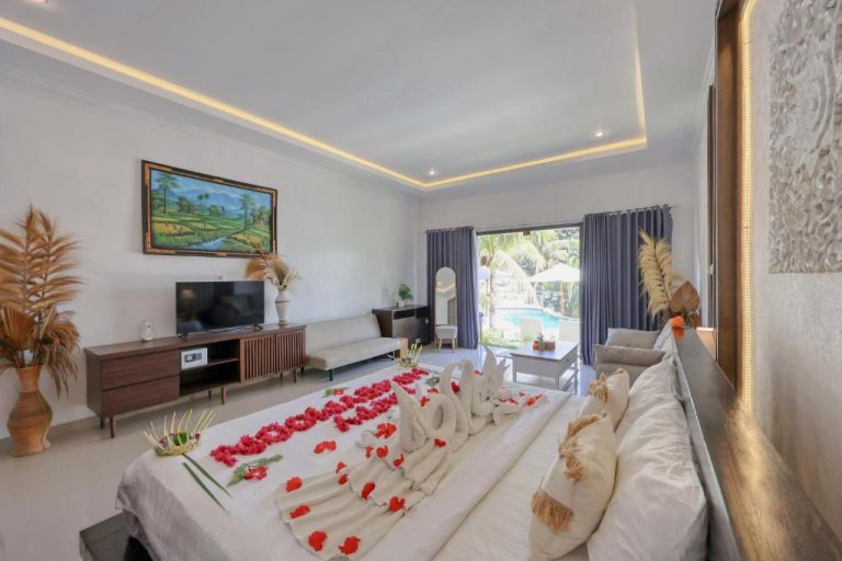 Habitación romántica con pétalos de rosa en la cama y vistas a la piscina en Kelingking Tropical
