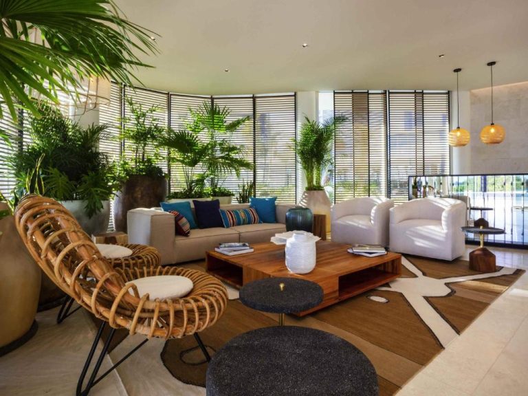 Elegante lobby lounge con mobiliario de diseño y plantas tropicales en el hotel SLS Cancun