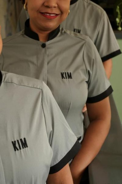 Personal del Hotel Kim con uniforme gris bordado con el nombre del establecimiento