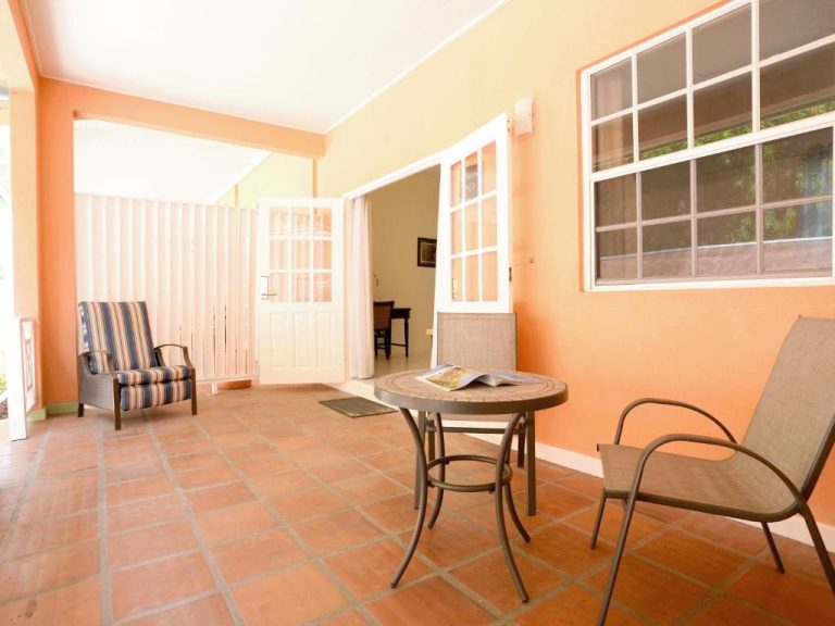 Terraza exterior con mesa y sillas del Worthing Court Apartment Hotel en Barbados