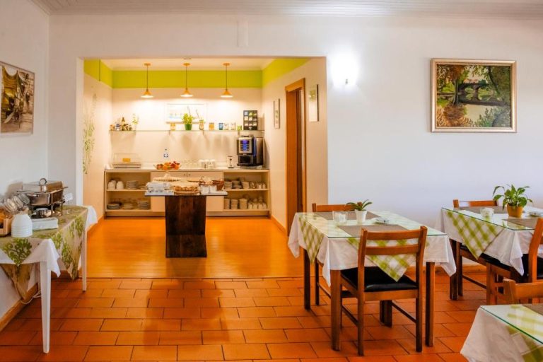 Salón de desayunos con buffet y mesas del Hotel Larverde, decorado en tonos verdes y blancos