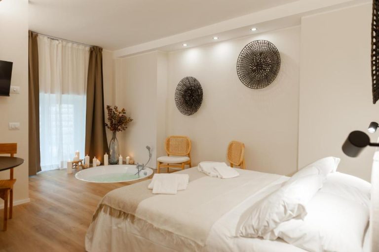 Suite de lujo con bañera jacuzzi integrada y cama doble en WelcHome Wellness Suites