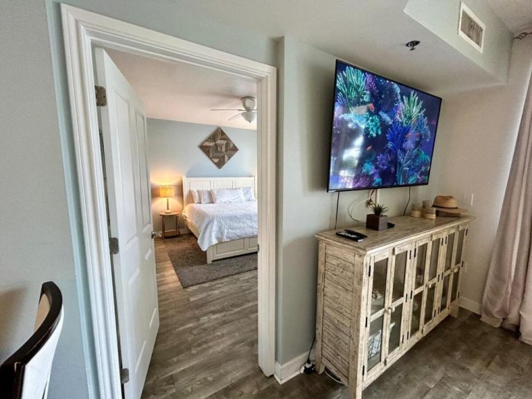 Salón con televisor de pantalla grande y vista al dormitorio con cama en Shores of Panama 315