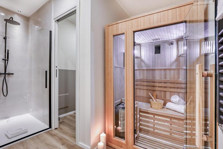Sauna privada de madera con ducha y accesorios de spa en WelcHome Wellness Suites