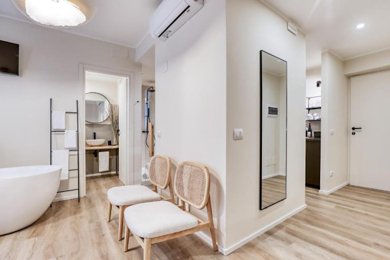 Suite con bañera exenta, sillas de ratán y espejo de cuerpo entero en WelcHome Wellness Suites