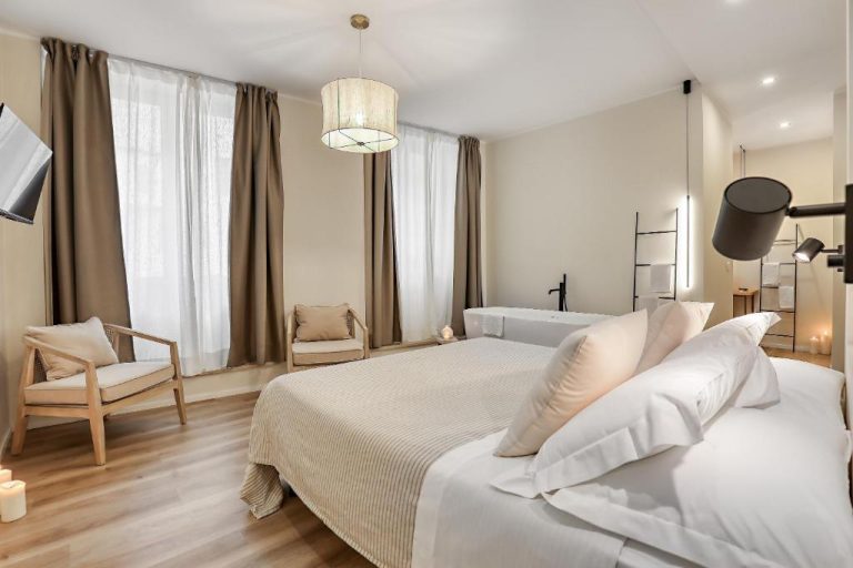 Suite de lujo con cama doble, bañera exenta y decoración nórdica en WelcHome Wellness Suites