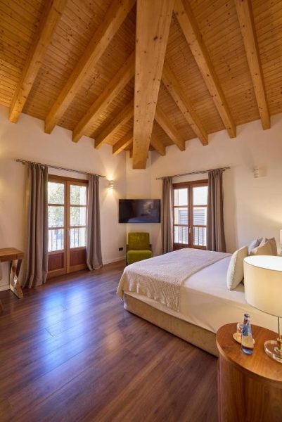 Habitación superior con techo de vigas de madera y suelo de parquet en Hotel Bosch Boutique