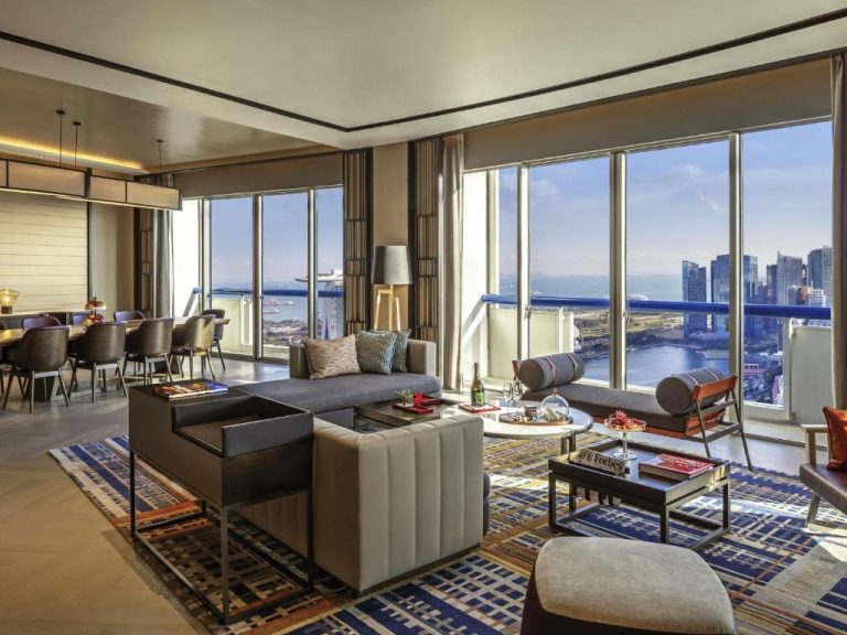 Suite de lujo con amplio salón y vistas panorámicas a la bahía en Swissotel The Stamford Singapore