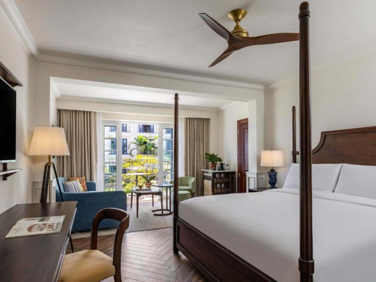 Habitación de lujo con cama dosel y balcón con vistas al jardín en Sofitel Legend Casco Viejo Panamá