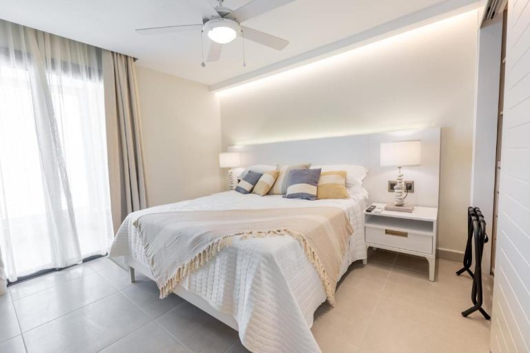 Habitación doble luminosa con cama king size y decoración en tonos blancos en Corner Penthouse Ocean City Views