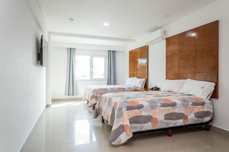 Habitación doble con dos camas y cabecero de madera en Suites Gaby Cancún