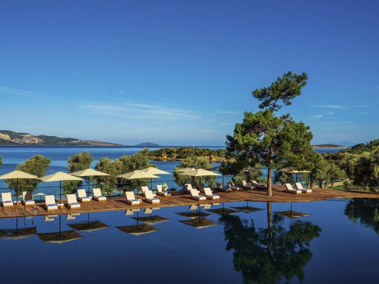 Piscina infinita con tumbonas y sombrillas del Rixos Premium Bodrum frente al mar Egeo