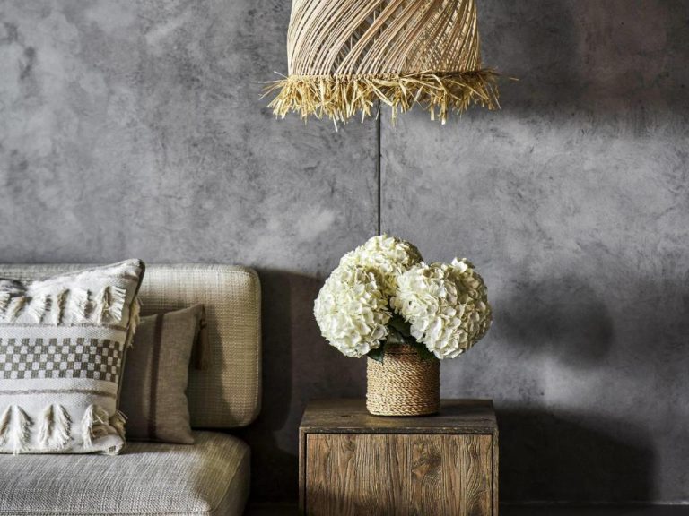 Salón con decoración boho chic, flores blancas y lámpara de mimbre en Rixos Premium Bodrum