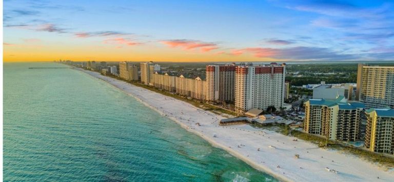 Vista aérea de la playa y edificios del Shores of Panama 315 en Panama City Beach al atardecer