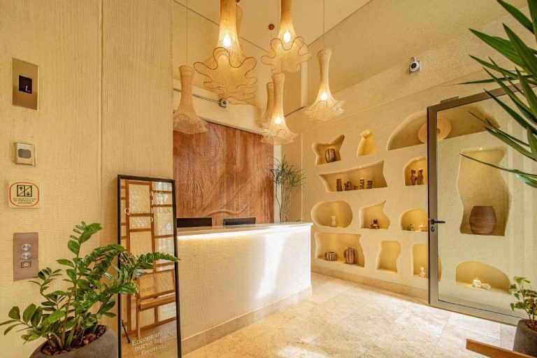 Recepción del Moabi Hotel con decoración artesanal, nichos en pared y lámparas de fibra natural
