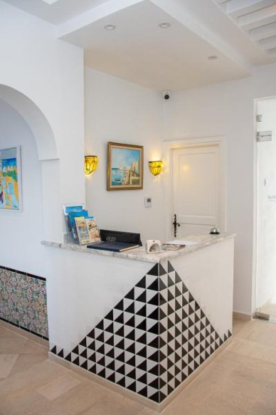 Recepción del Hôtel Al Jazira Mahdia con mostrador decorado en mosaico blanco y negro