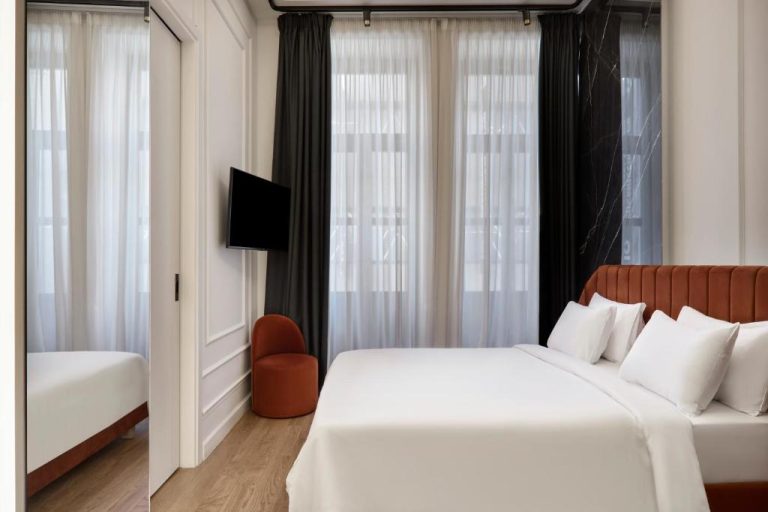 Habitación doble de lujo con cabecero de terciopelo y ventanales en Athens Icon Collection