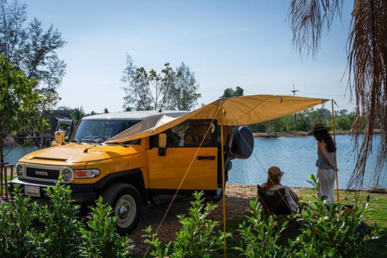 Toyota FJ Cruiser amarillo con toldo de glamping junto al lago en Camp Cayla COASTA